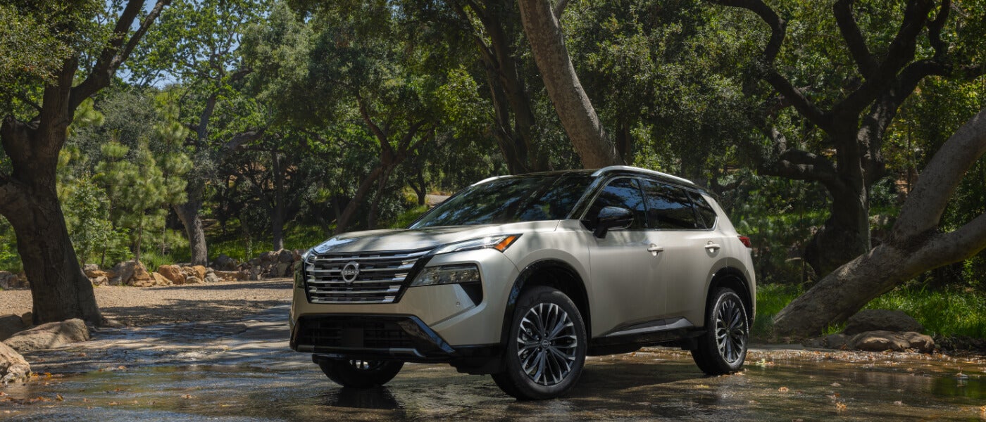 2026 Nissan Rogue Exterior Driving Through Forest